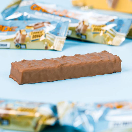 Ein einzelner Grenade Proteinriegel Chocolate Chip Cookie Dough liegt ohne Verpackung auf einem Tisch.