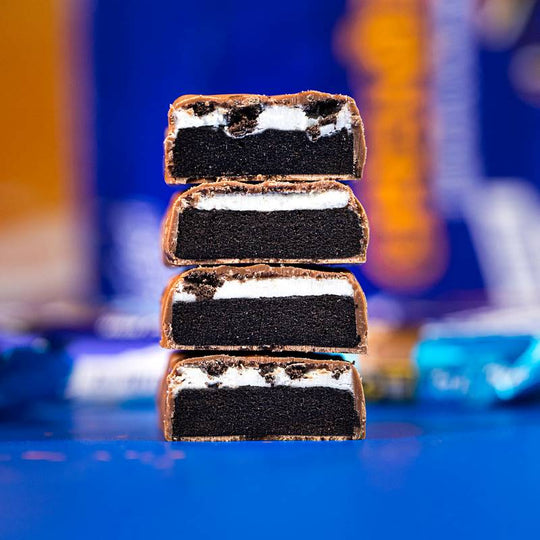 Vier gestapelte Grenade Oreo Proteinriegel, in der Mitte durchgeschnitten.
