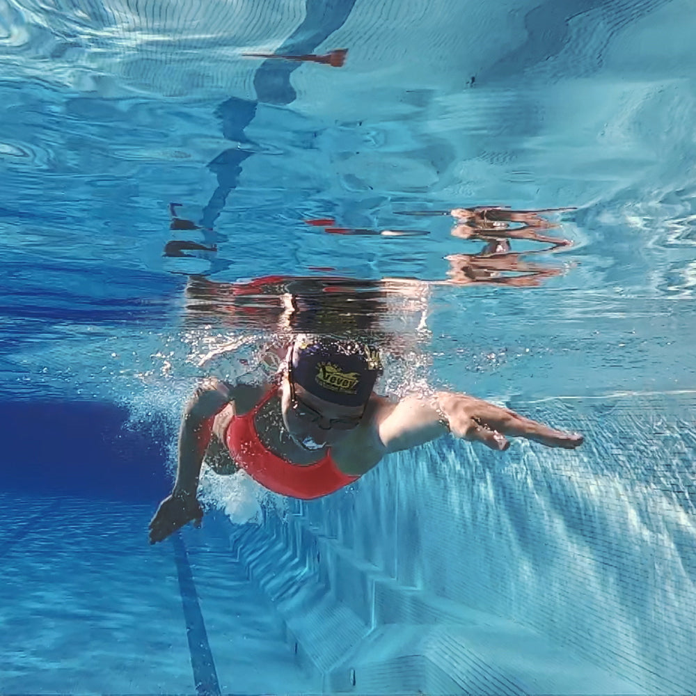 Frau schwimmt im Pool und hat einen roten Badeanzug an